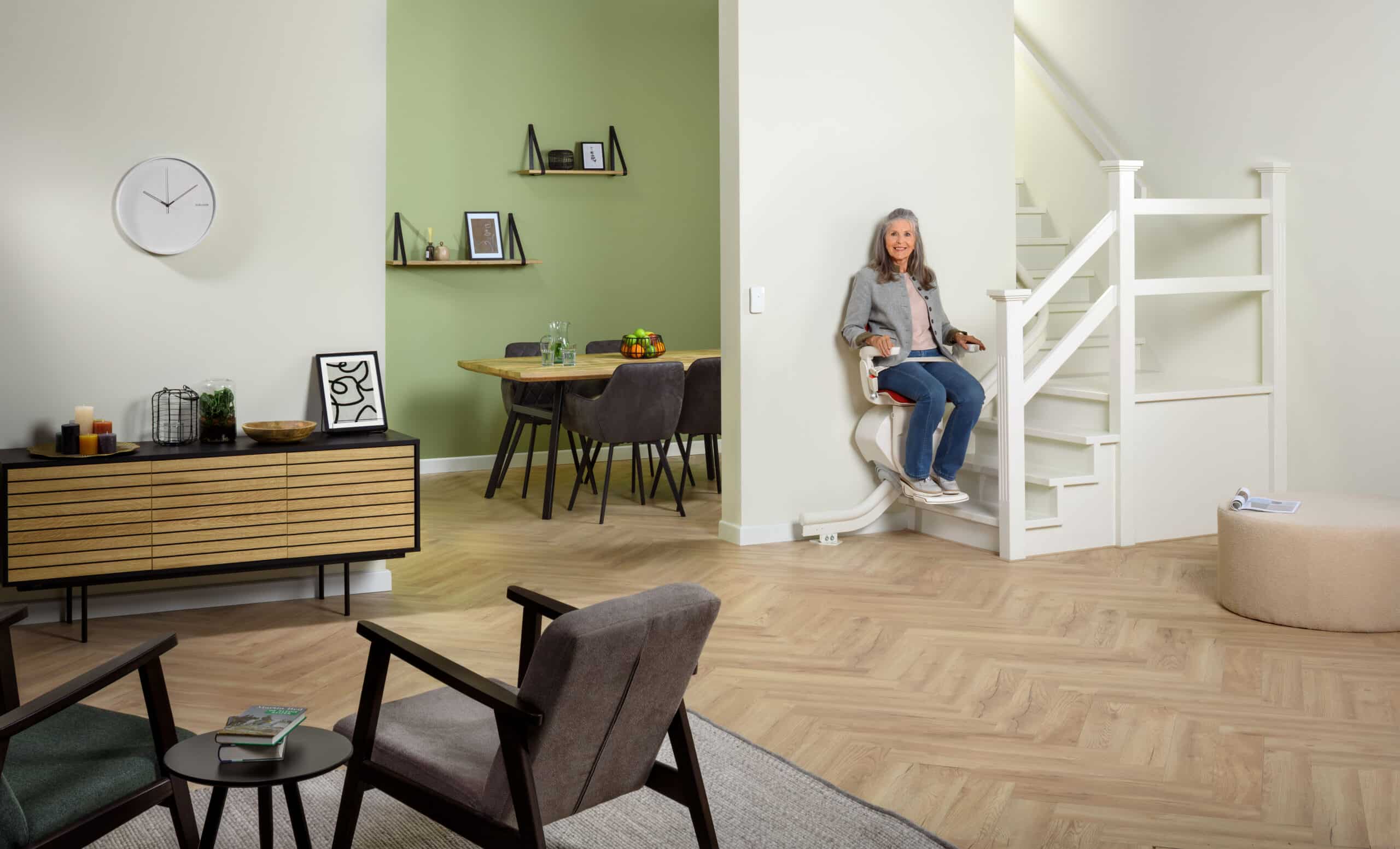 Vrouw gebruikt een Otolift traplift op een rechte trap in huis